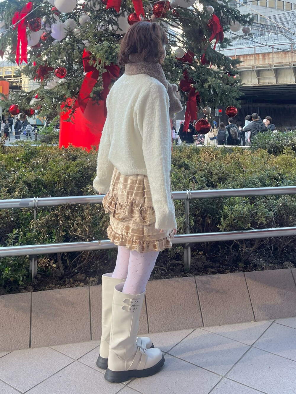 ホワイト系のカーディガン/ボレロ、ホワイト系のダウンジャケット/コート、ブラウン系のスカートを着用したレディースの冬コーディネートの9枚目の写真