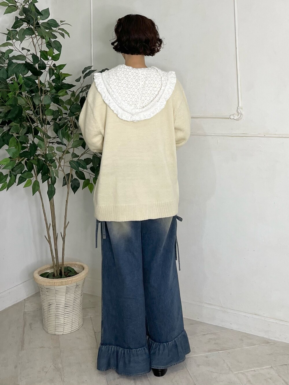 ホワイト系のTシャツ/カットソー、ホワイト系のニット/セーター、ブルー系のデニムパンツを着用したレディースの秋コーディネートの3枚目の写真