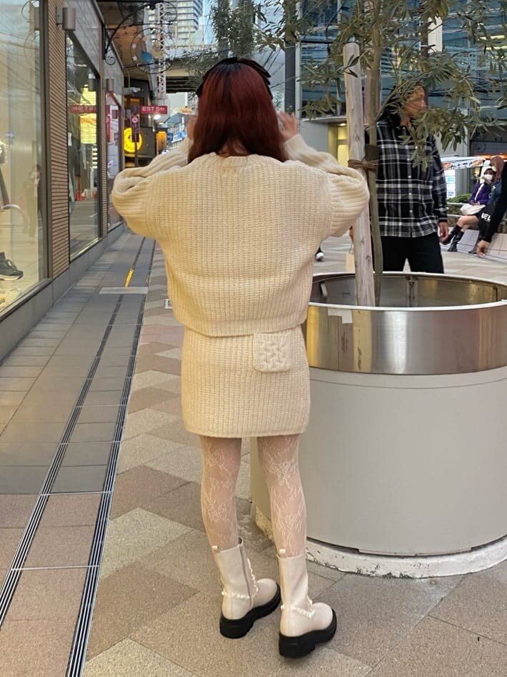 ホワイト系のブーツ、ホワイト系のスカート、ホワイト系のニット/セーターを着用したレディースの秋コーディネートの2枚目の写真