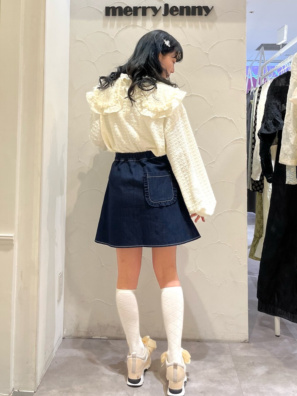 ブルー系のデニムスカート、ホワイト系のTシャツ/カットソー、ホワイト系のスニーカーを着用したレディースの冬コーディネートの5枚目の写真