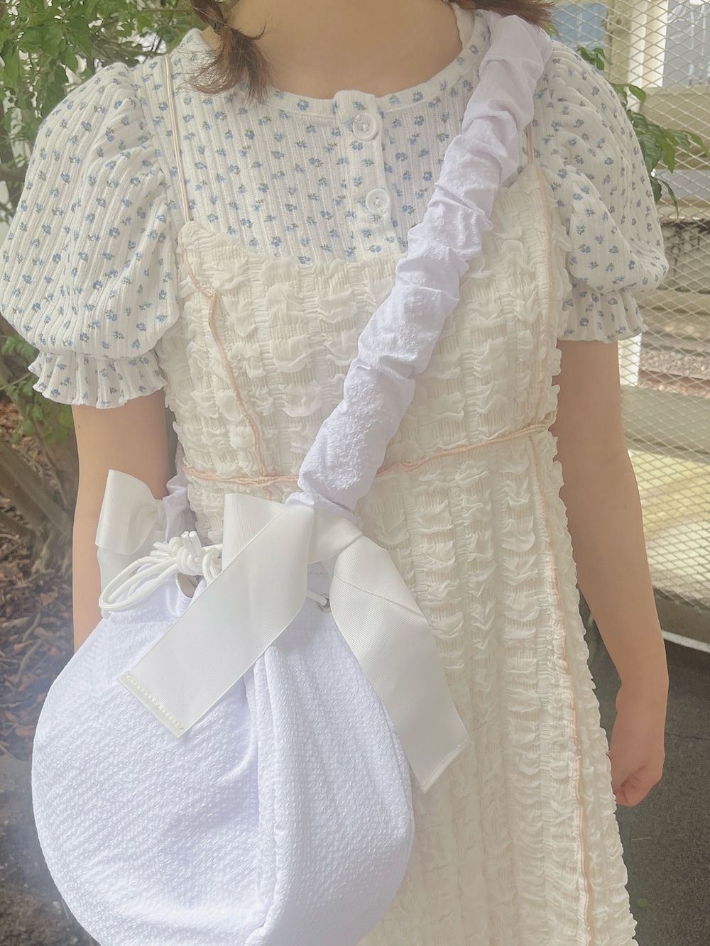 ブルー系のTシャツ/カットソー、ホワイト系のワンピース、ホワイト系のショルダーバッグを着用したレディースの夏コーディネートの6枚目の写真