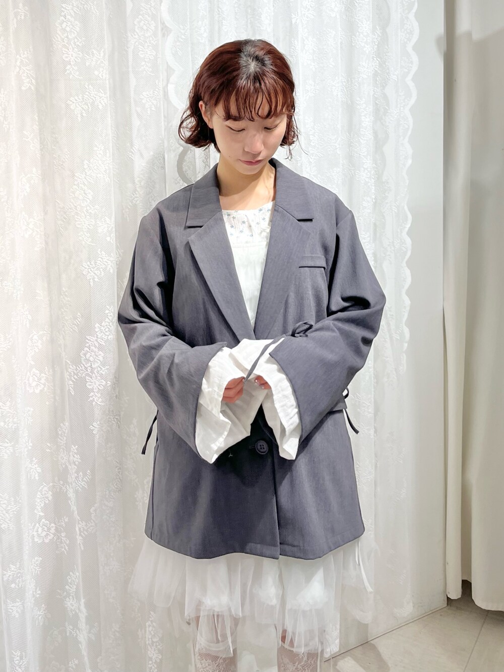 グレー系のテーラードジャケット、ブルー系のTシャツ/カットソー、ホワイト系のワンピースを着用したレディースの冬コーディネートの7枚目の写真
