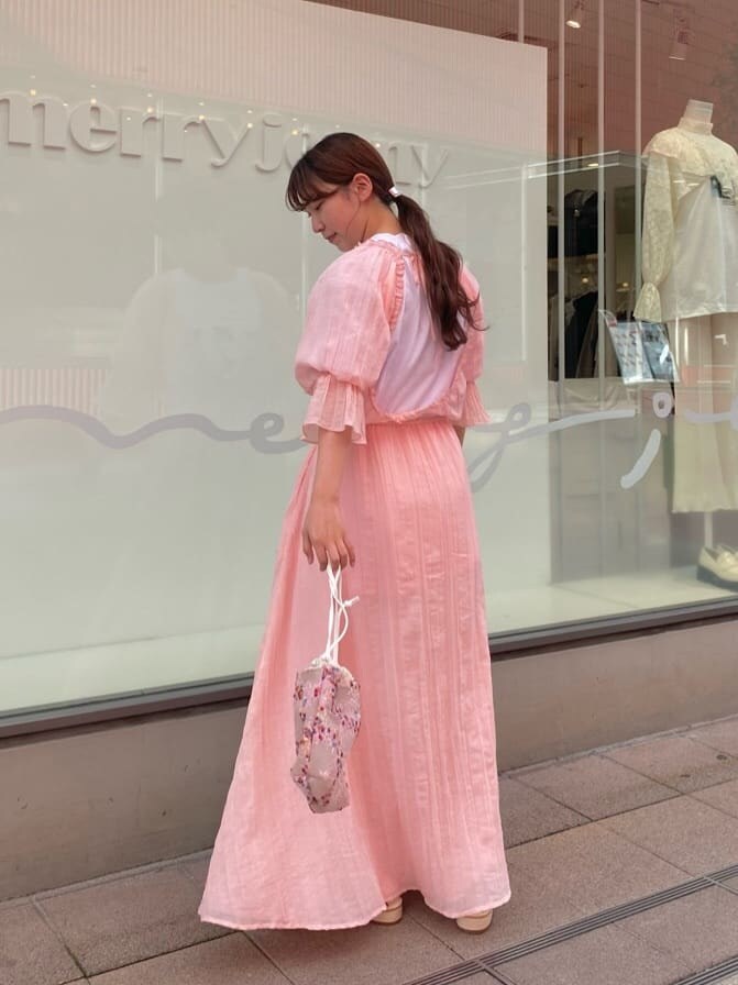 ピンク系のワンピース、ピンク系のパンプス、ピンク系のハンドバッグを着用したレディースの春コーディネートの3枚目の写真