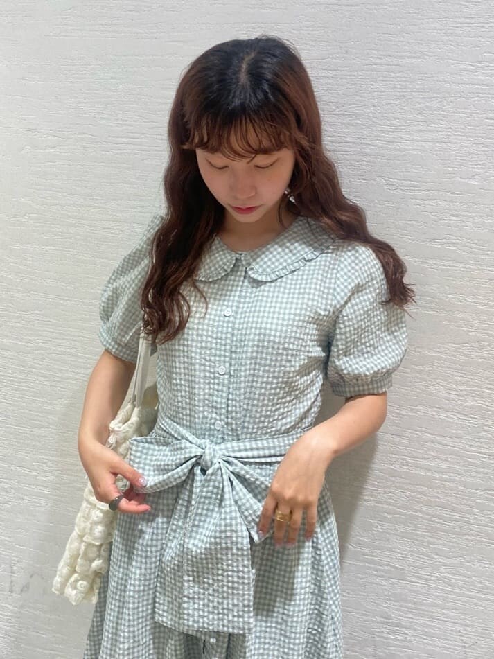 ホワイト系のサンダル、ホワイト系のトートバッグ、グリーン系のワンピースを着用したレディースの春コーディネートの5枚目の写真