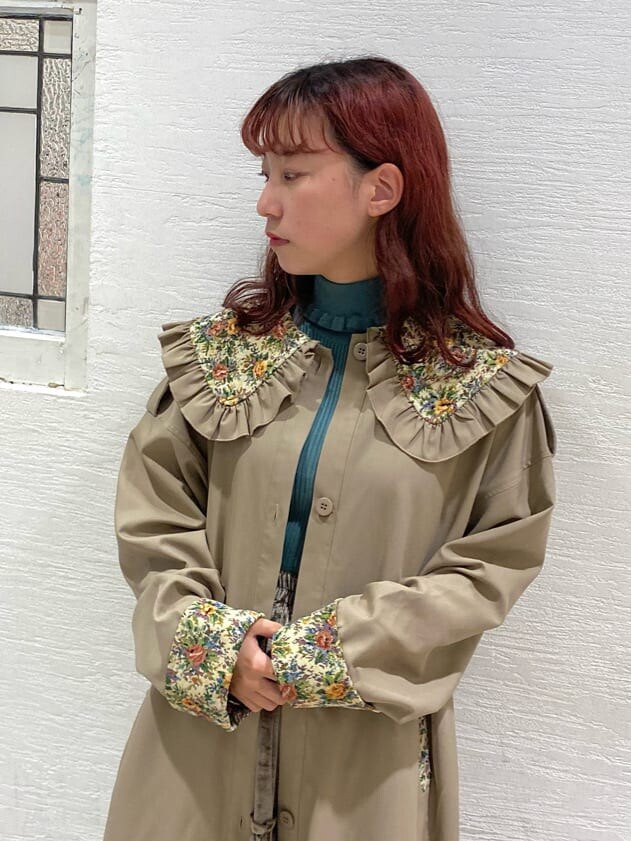 ブラウン系のスカート、ベージュ系のトレンチコート、ブラウン系のブーツを着用したレディースの秋コーディネートの4枚目の写真