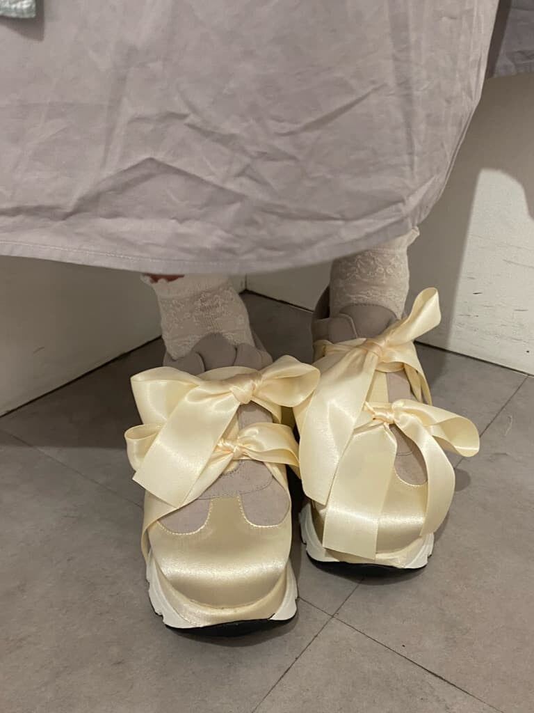 グレー系のワンピース、ホワイト系のスニーカーを着用したレディースの冬コーディネートの5枚目の写真