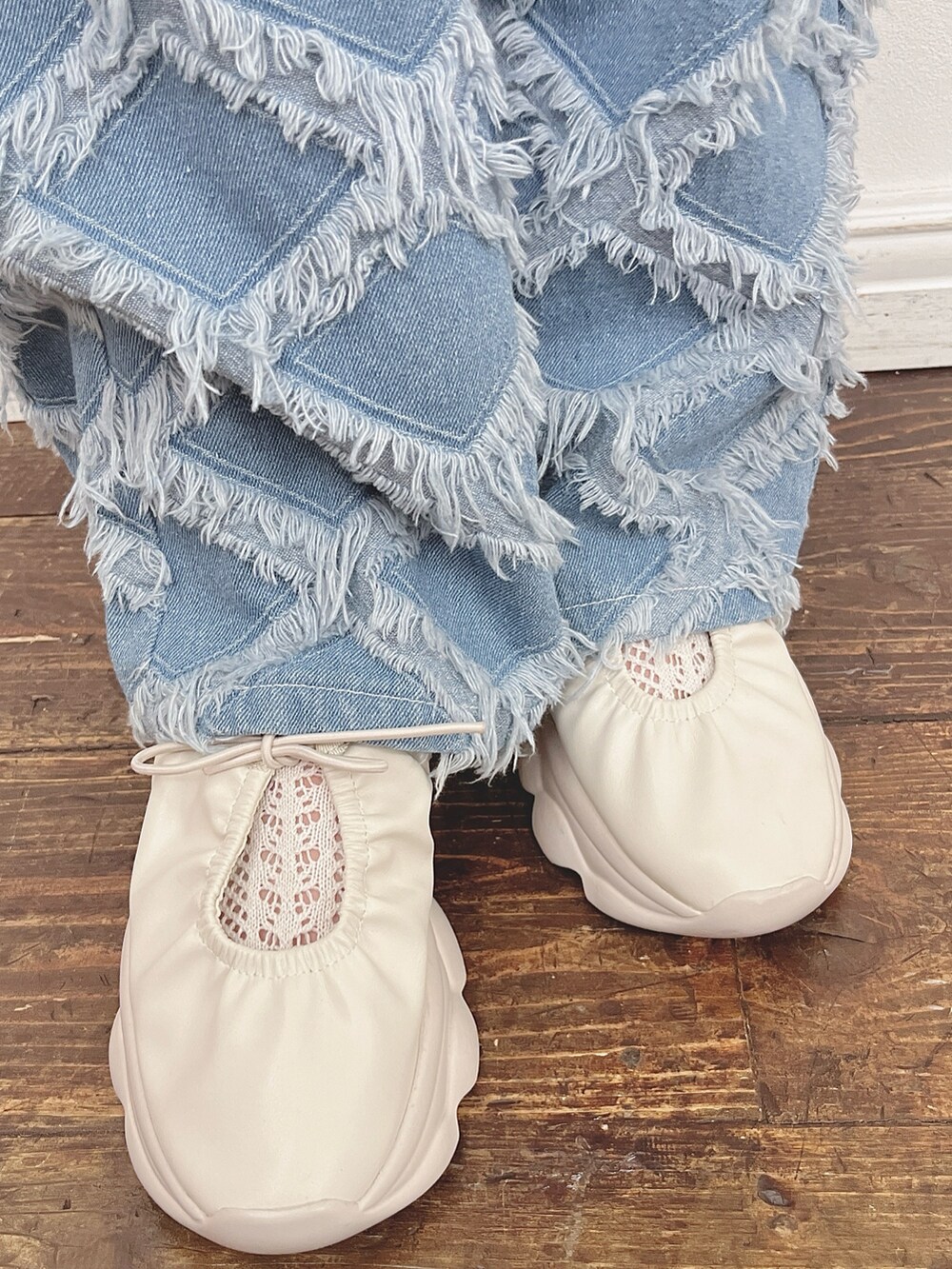 ブルー系のデニムパンツ、ホワイト系のスニーカー、ホワイト系のスウェットを着用したレディースの夏コーディネートの4枚目の写真