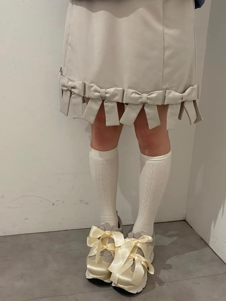 ホワイト系のシャツ/ブラウス、ベージュ系のスカート、ホワイト系のスニーカーを着用したレディースの冬コーディネートの5枚目の写真