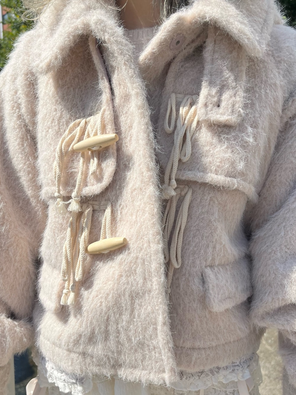 ピンク系のダッフルコート、ホワイト系のニット/セーター、ホワイト系のその他パンツを着用したレディースの秋コーディネートの8枚目の写真