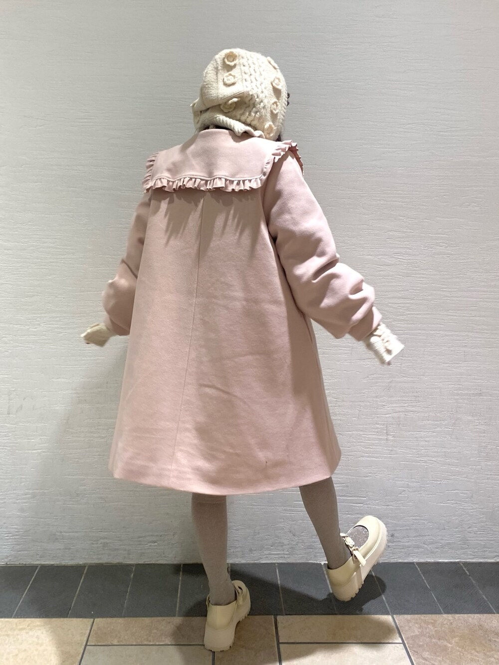 ピンク系のステンカラーコート、ホワイト系のローファー、ホワイト系のニットキャップ/ビーニーを着用したレディースの冬コーディネートの3枚目の写真