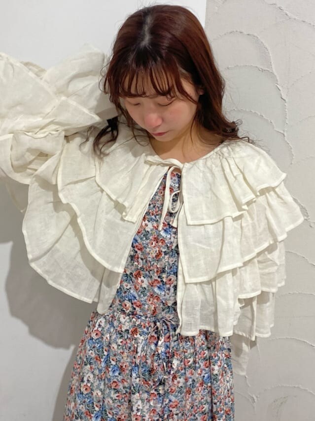 ピンク系のワンピース、ホワイト系のカーディガン/ボレロ、ホワイト系のパンプスを着用したレディースの冬コーディネートの4枚目の写真