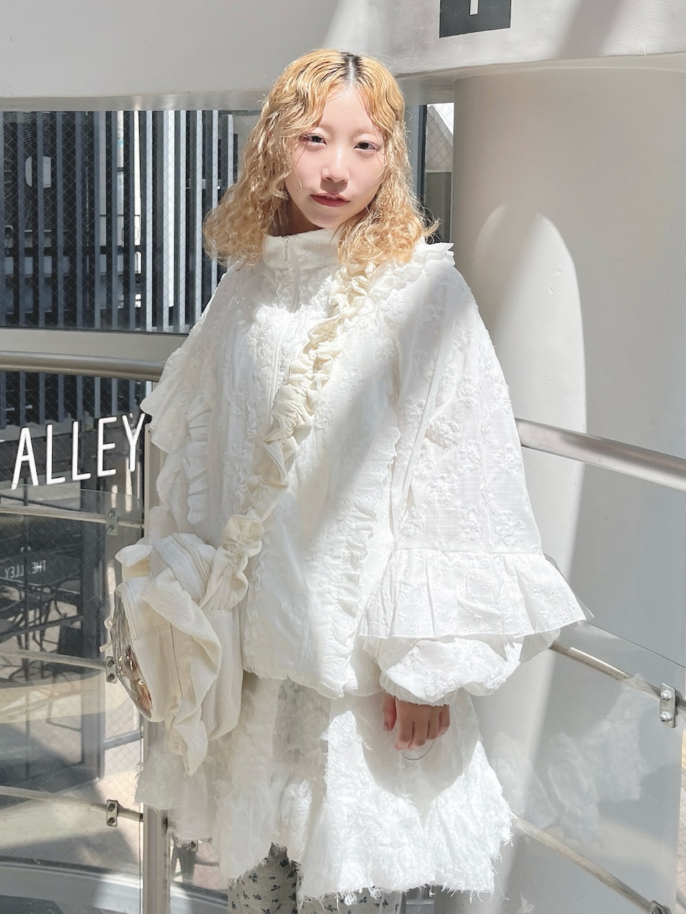 ホワイト系のブルゾン、ホワイト系のショルダーバッグ、ホワイト系のワンピースを着用したレディースの夏コーディネートの4枚目の写真