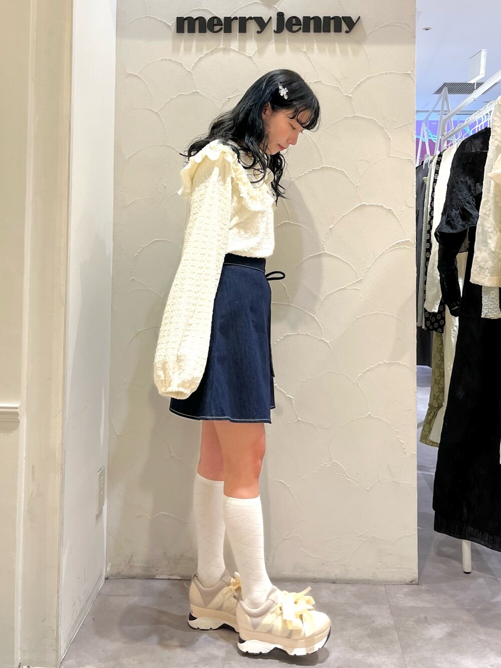 ブルー系のデニムスカート、ホワイト系のTシャツ/カットソー、ホワイト系のスニーカーを着用したレディースの冬コーディネートの4枚目の写真