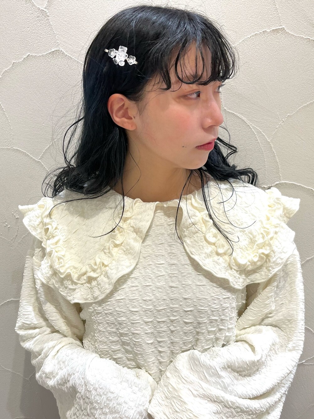 ブルー系のデニムスカート、ホワイト系のTシャツ/カットソー、ホワイト系のスニーカーを着用したレディースの冬コーディネートの6枚目の写真