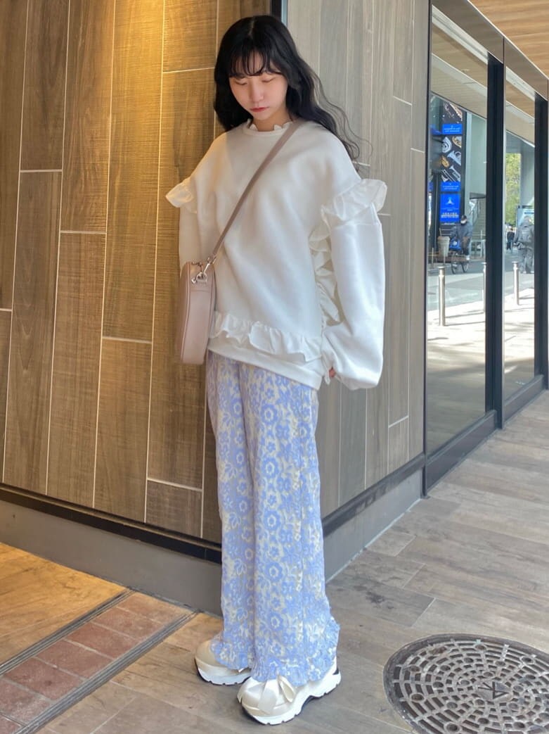 ブルー系のその他パンツ、ホワイト系のスニーカー、ピンク系のショルダーバッグを着用したレディースの春コーディネートの2枚目の写真