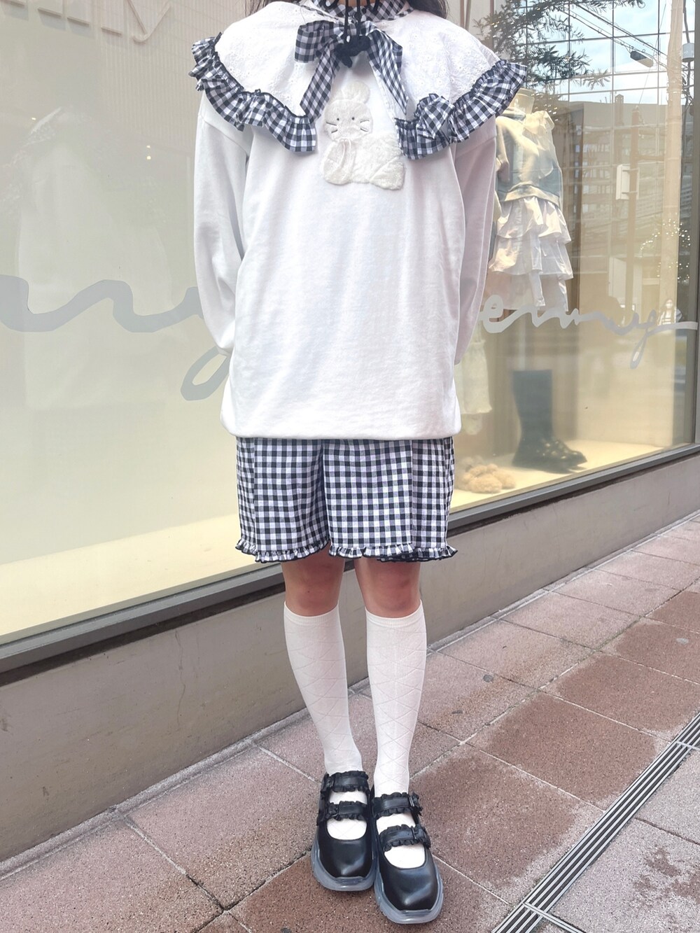 ホワイト系のスウェット、ブラック系のワンピース、ブラック系のスニーカーを着用したレディースの冬コーディネートの8枚目の写真