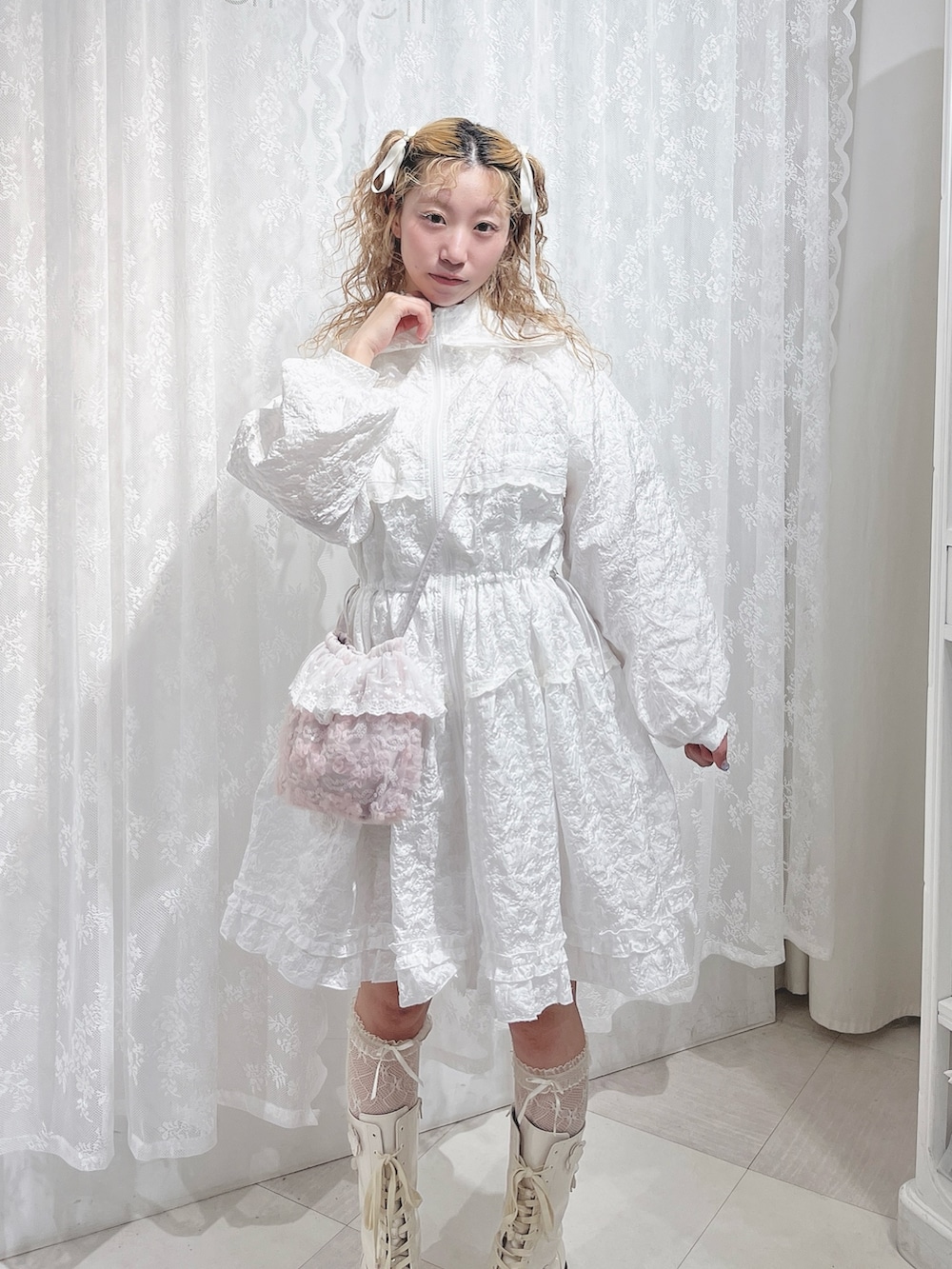 ホワイト系のワンピース、ピンク系のハンドバッグ、ホワイト系のブーツを着用したレディースの夏コーディネートの5枚目の写真