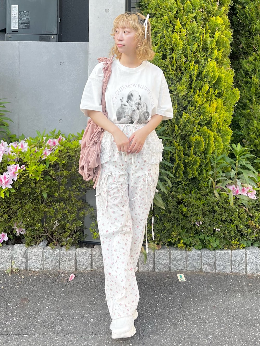 ホワイト系のTシャツ/カットソー、ホワイト系のスラックス、ピンク系のトートバッグを着用したレディースの春コーディネートの2枚目の写真