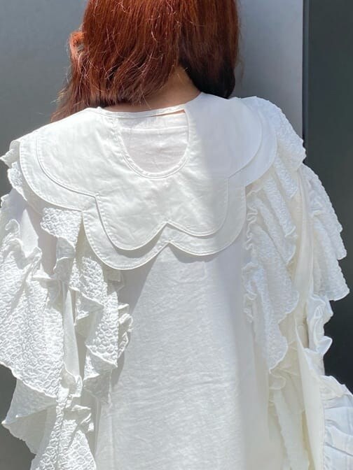 ホワイト系のチュニック、ホワイト系のその他パンツ、ホワイト系のサンダルを着用したレディースの春コーディネートの5枚目の写真