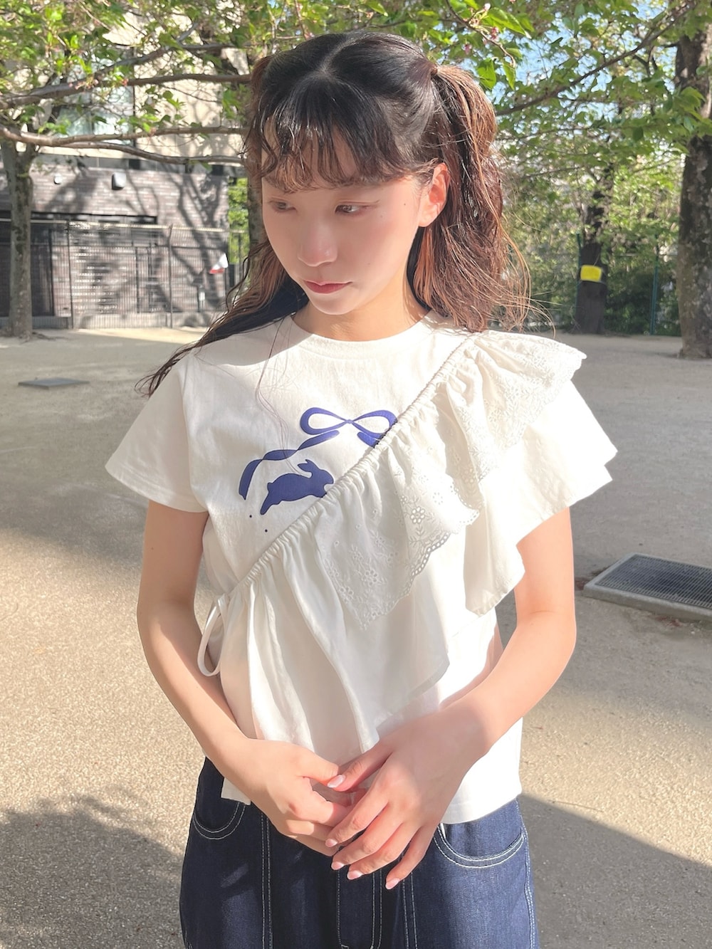 ホワイト系のTシャツ/カットソー、ブルー系のデニムパンツ、ホワイト系のスニーカーを着用したレディースの春コーディネートの3枚目の写真