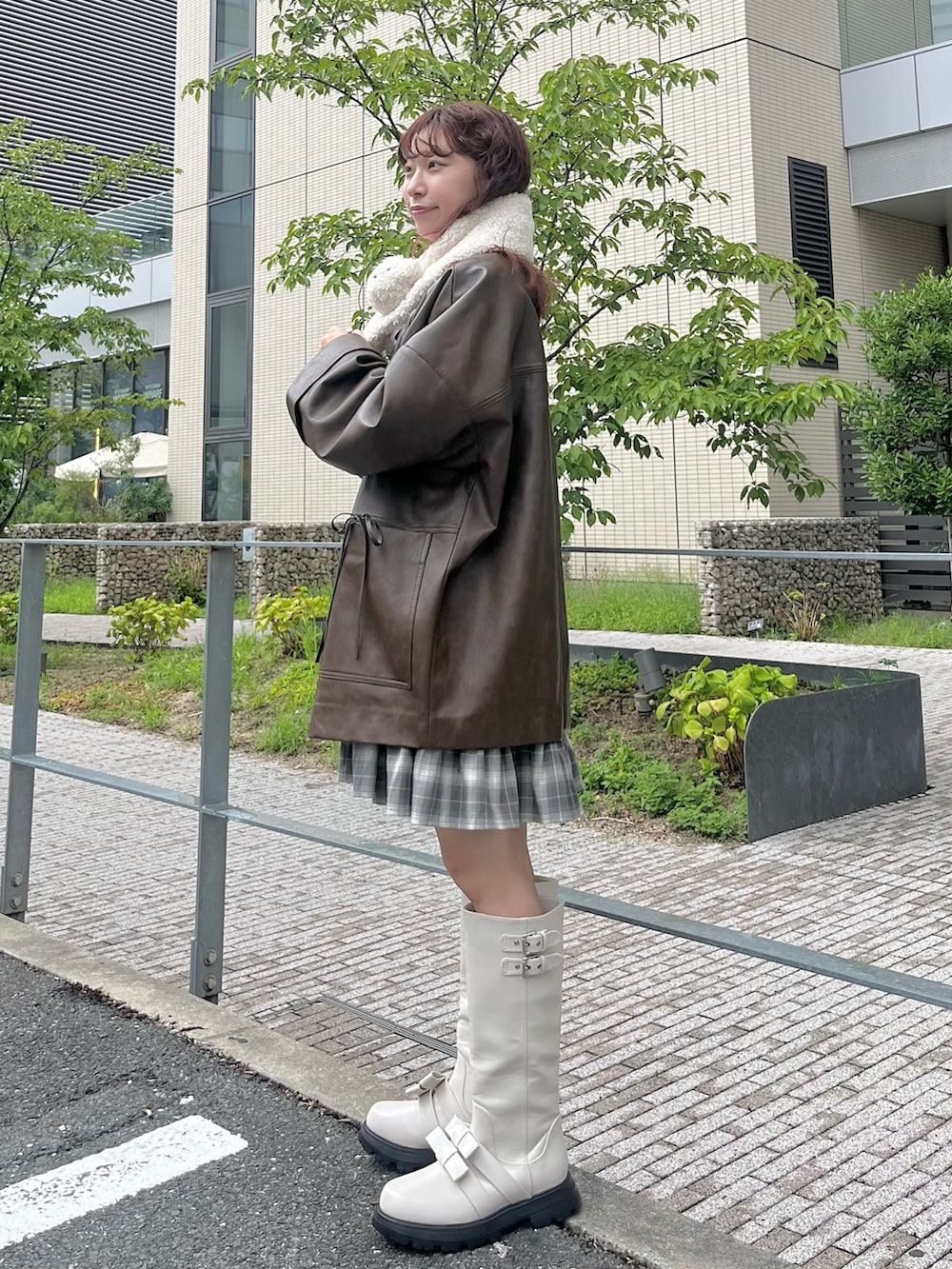 グレー系のワンピース、ホワイト系のブーツ、ブラウン系のブルゾンを着用したレディースの夏コーディネートの2枚目の写真