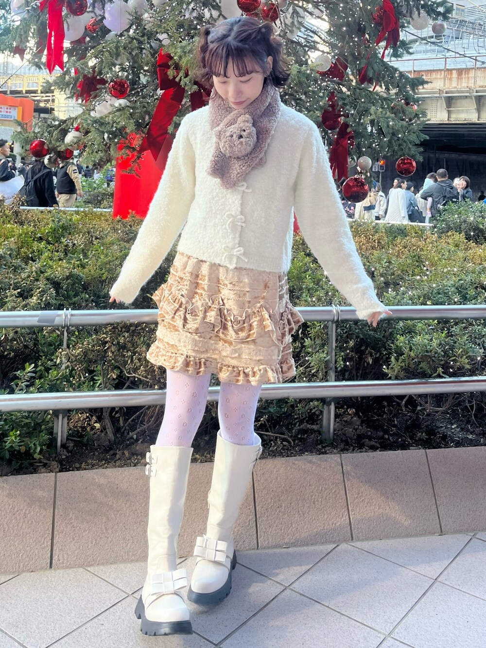 ホワイト系のカーディガン/ボレロ、ホワイト系のダウンジャケット/コート、ブラウン系のスカートを着用したレディースの冬コーディネートの8枚目の写真