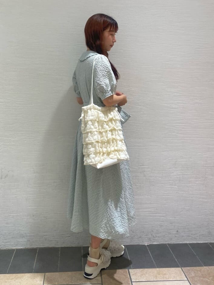 ホワイト系のサンダル、ホワイト系のトートバッグ、グリーン系のワンピースを着用したレディースの春コーディネートの3枚目の写真