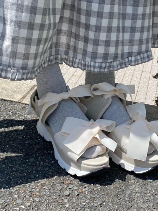 グレー系のスカート、ホワイト系のTシャツ/カットソー、ホワイト系のショルダーバッグを着用したレディースの夏コーディネートの6枚目の写真