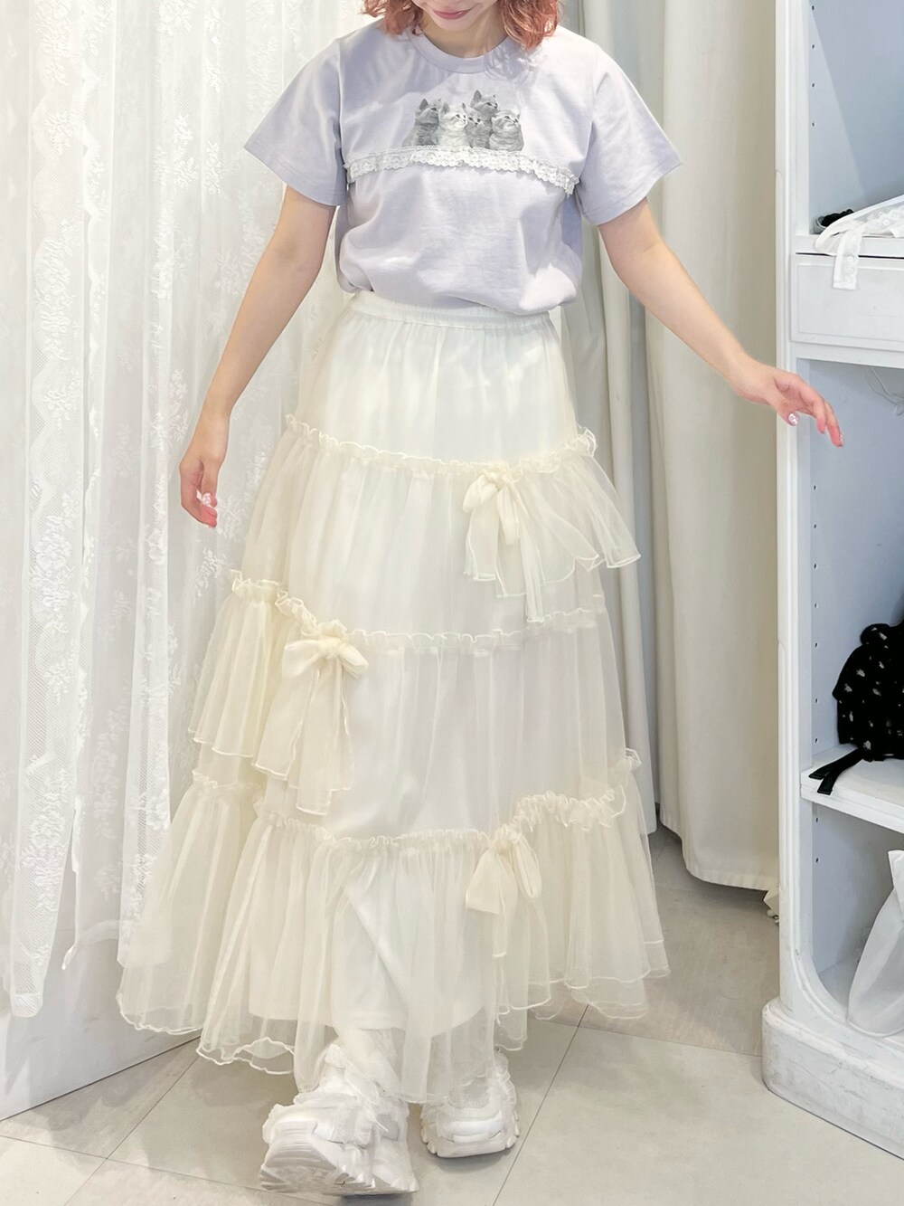 ブルー系のTシャツ/カットソー、ホワイト系のスカート、ホワイト系のスニーカーを着用したレディースの春コーディネートの4枚目の写真