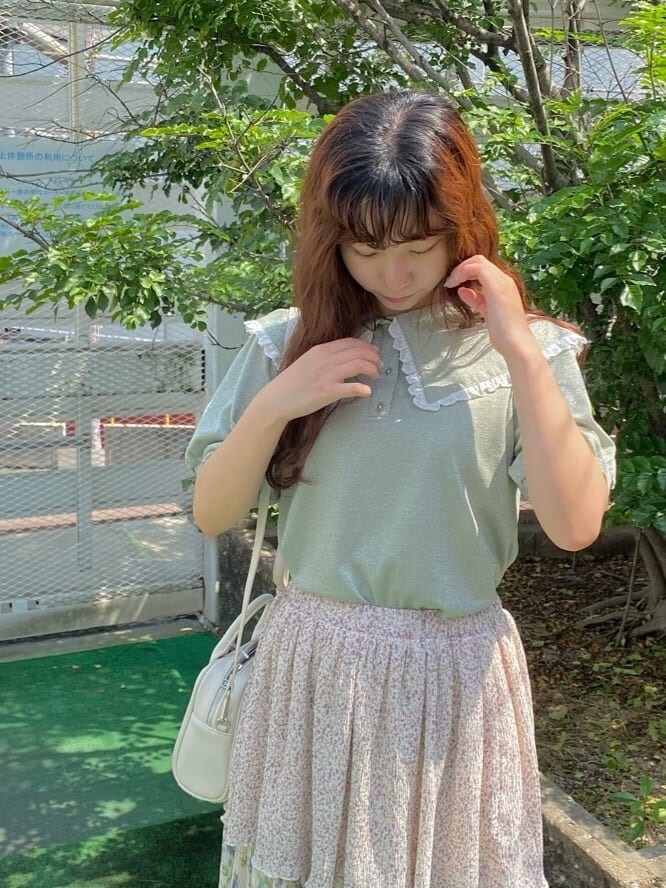 ホワイト系のスカート、ホワイト系のサンダル、グリーン系のTシャツ/カットソーを着用したレディースの夏コーディネートの3枚目の写真