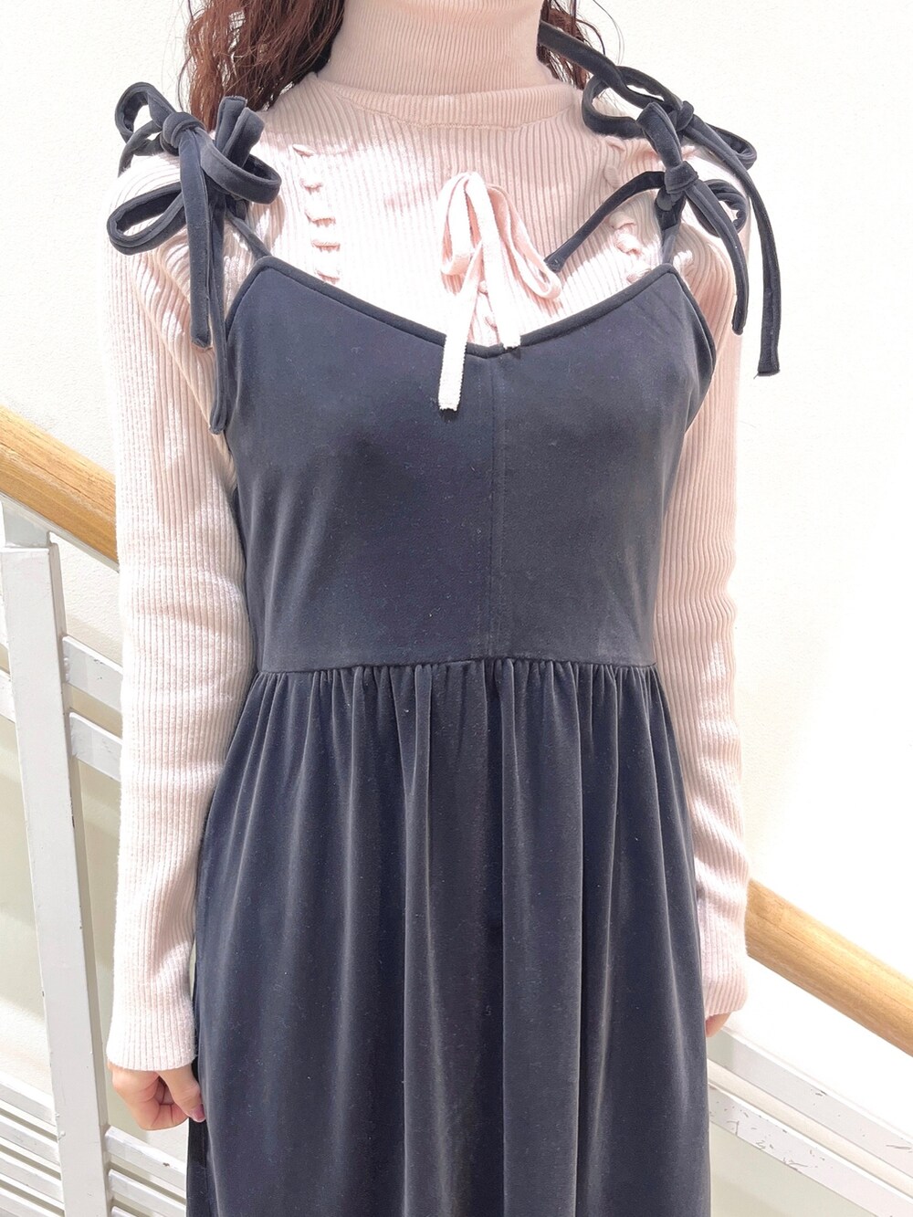 ピンク系のニット/セーター、グレー系のワンピース、ホワイト系のパンプスを着用したレディースの冬コーディネートの7枚目の写真