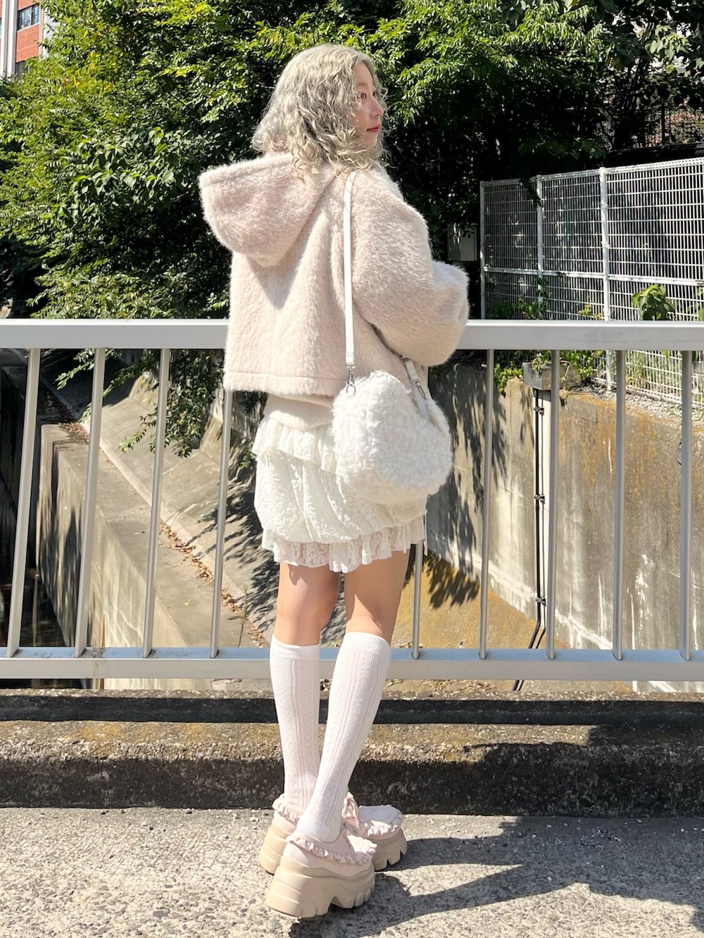 ピンク系のダッフルコート、ホワイト系のニット/セーター、ホワイト系のその他パンツを着用したレディースの秋コーディネートの2枚目の写真