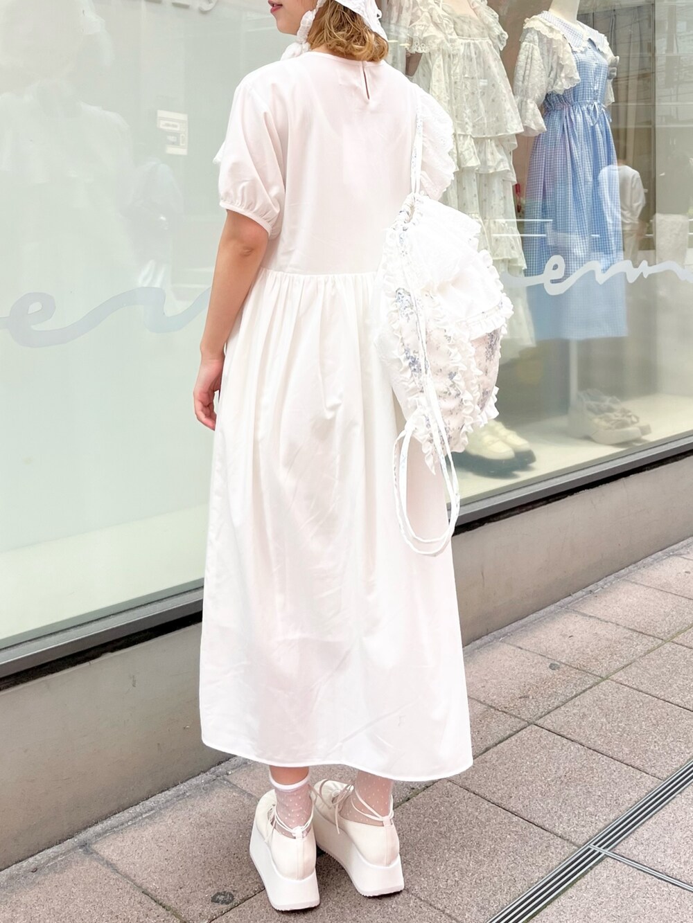 ホワイト系のワンピース、ブルー系のバックパック/リュック、ホワイト系のバレエシューズを着用したレディースの春コーディネートの6枚目の写真