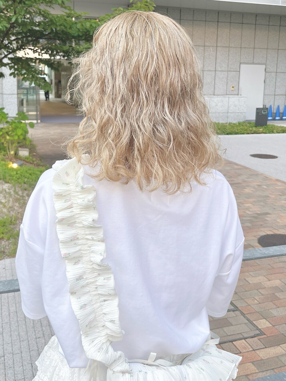 ホワイト系のショルダーバッグ、ホワイト系のTシャツ/カットソー、ホワイト系のスカートを着用したレディースの夏コーディネートの6枚目の写真