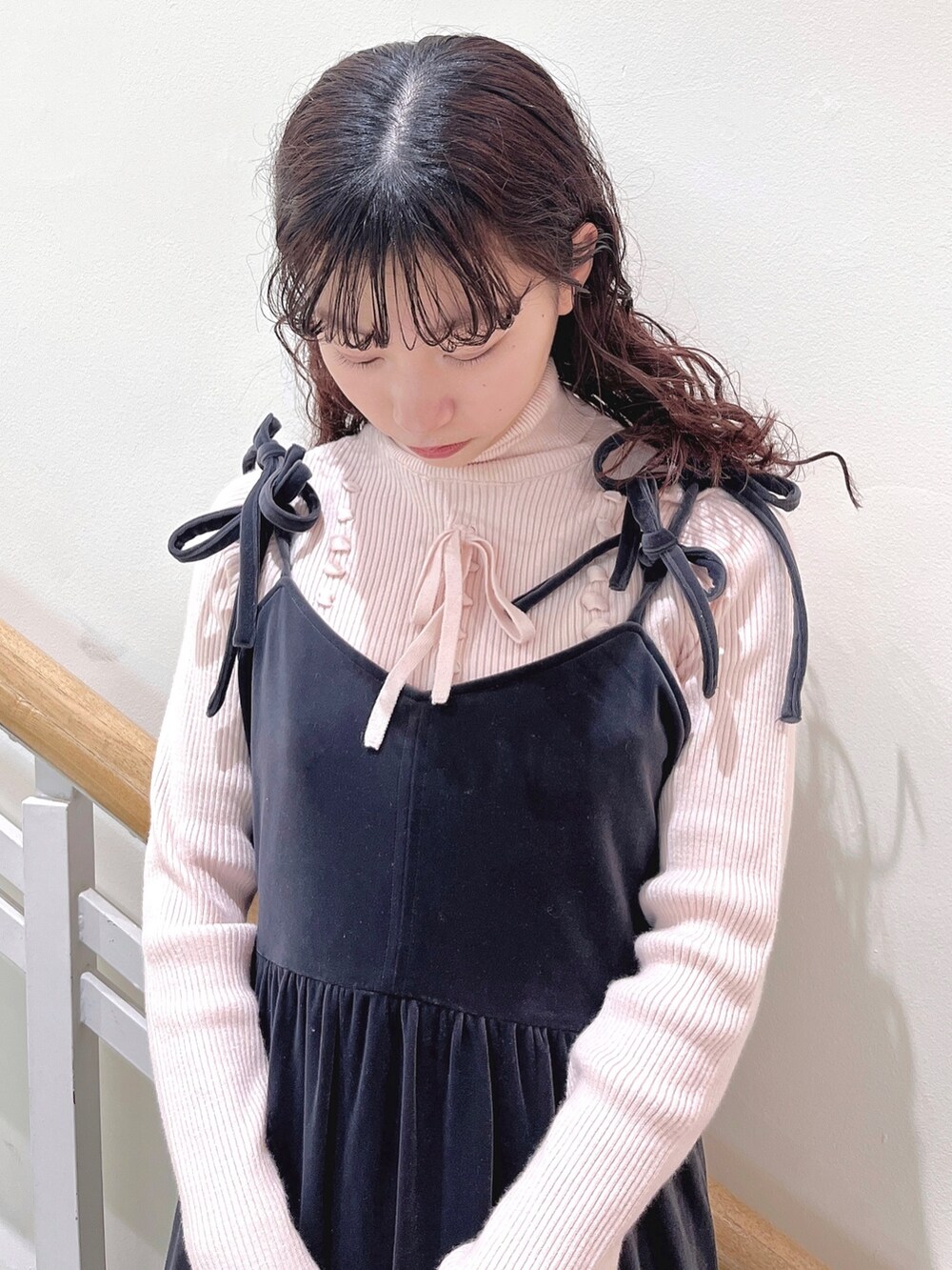 ピンク系のニット/セーター、グレー系のワンピース、ホワイト系のパンプスを着用したレディースの冬コーディネートの5枚目の写真