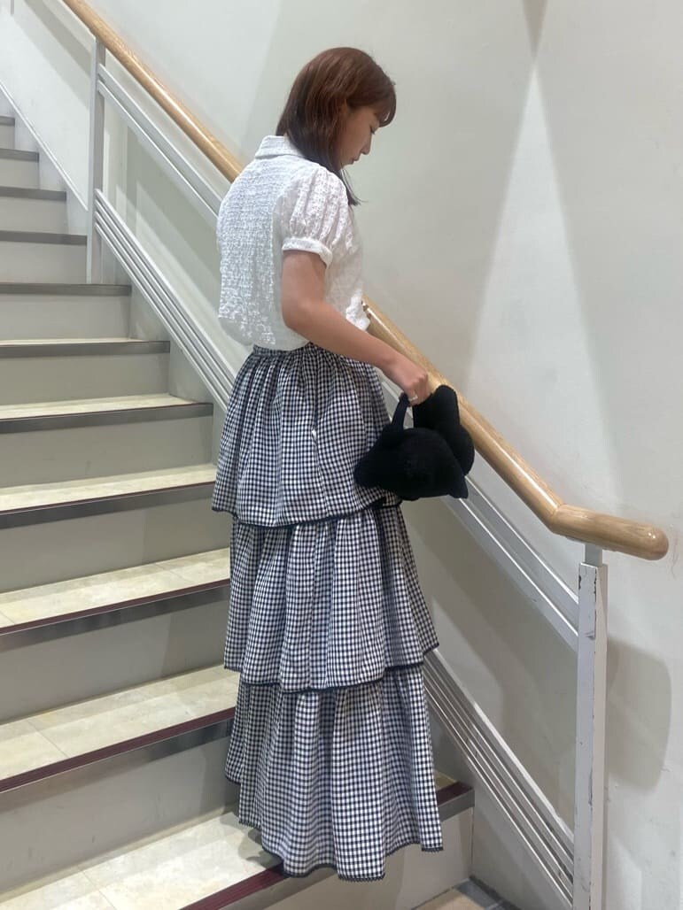 ブラック系のスニーカー、ホワイト系のシャツ/ブラウス、ブラック系のスカートを着用したレディースの夏コーディネートの3枚目の写真