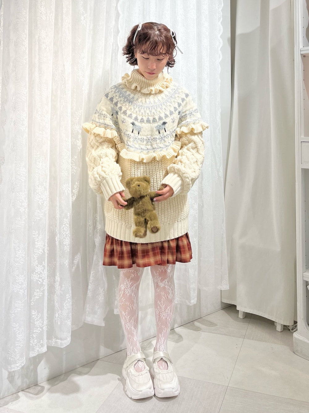 ホワイト系のニット/セーター、レッド系のワンピース、ホワイト系のスニーカーを着用したレディースの秋コーディネートの2枚目の写真