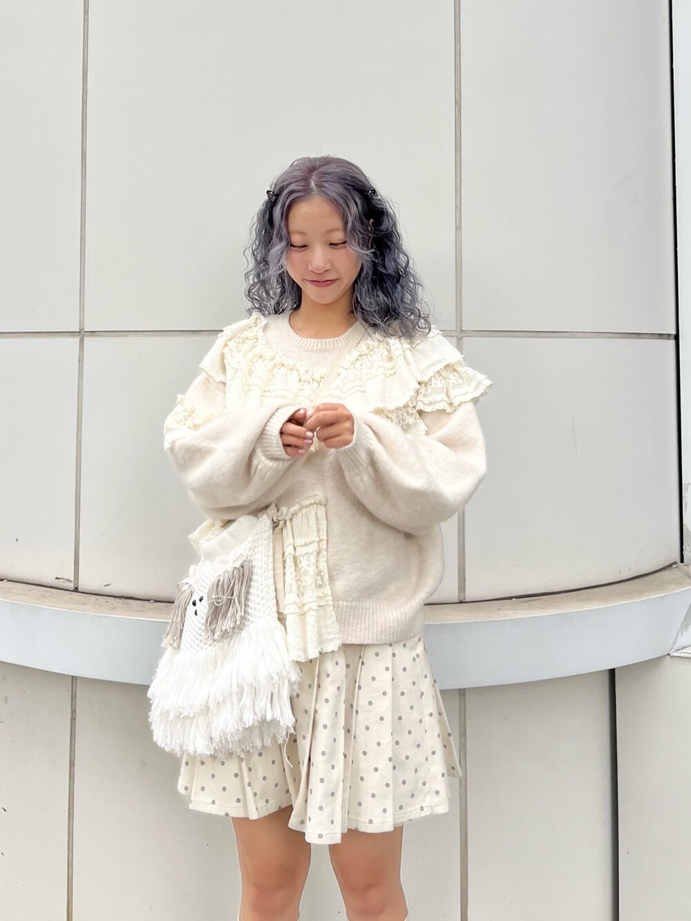 ホワイト系のニット/セーター、ホワイト系のスカート、ベージュ系のショルダーバッグを着用したレディースの秋コーディネートの5枚目の写真