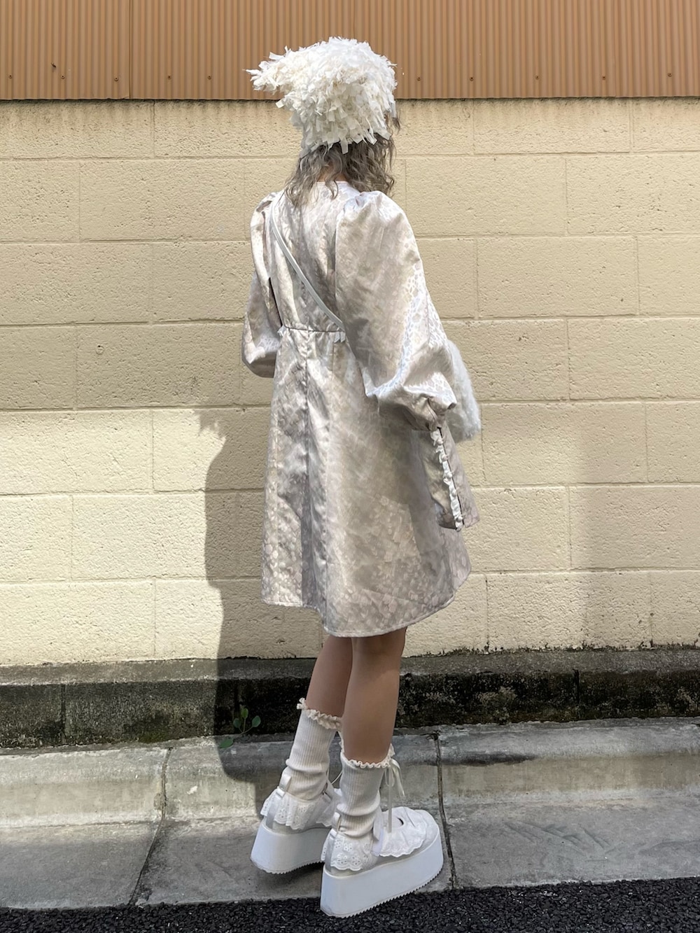 ピンク系のワンピース、ホワイト系のショルダーバッグ、ホワイト系のスニーカーを着用したレディースの秋コーディネートの3枚目の写真