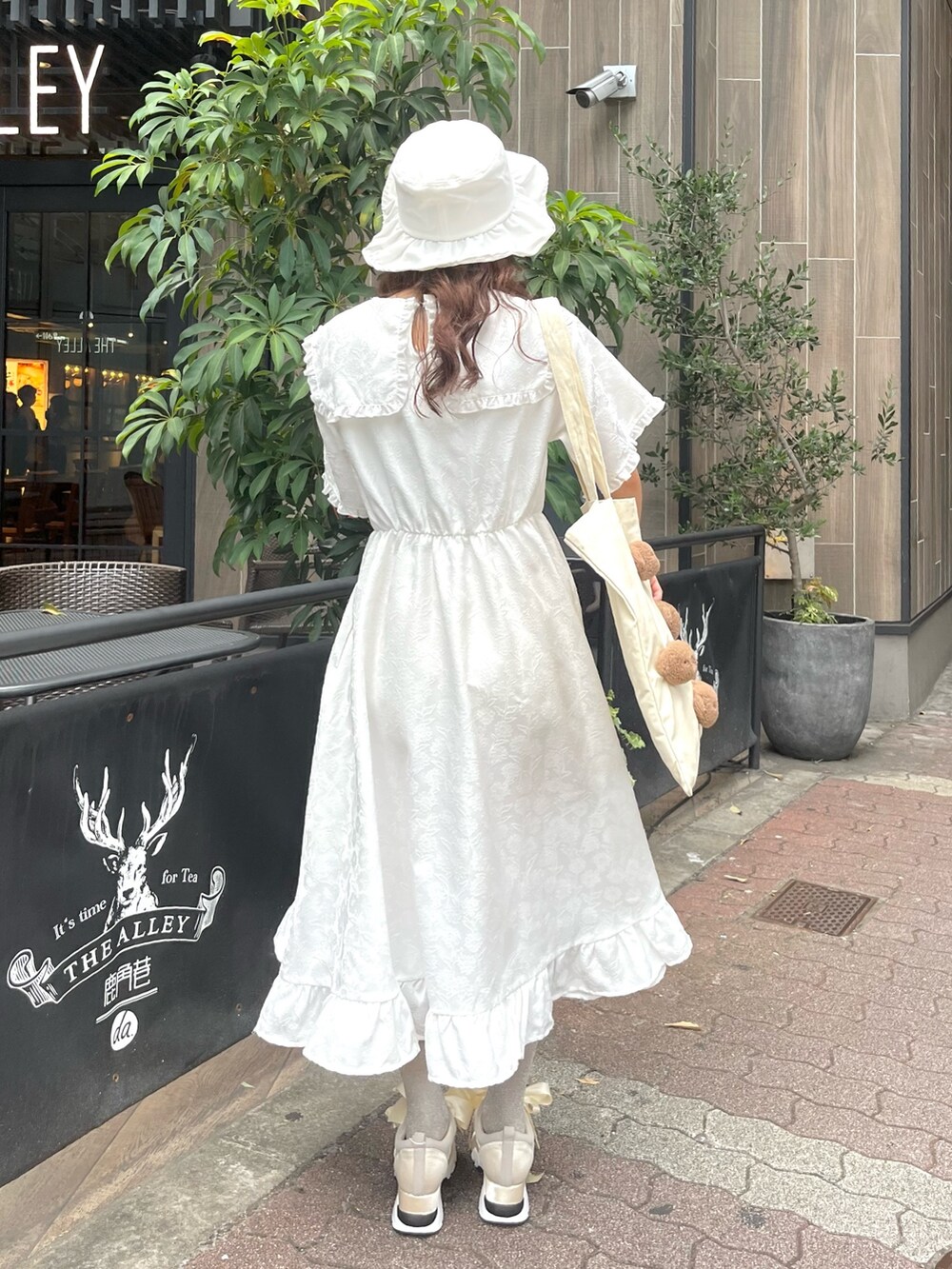 ホワイト系のスニーカー、ホワイト系のワンピース、ホワイト系のトートバッグを着用したレディースの夏コーディネートの2枚目の写真