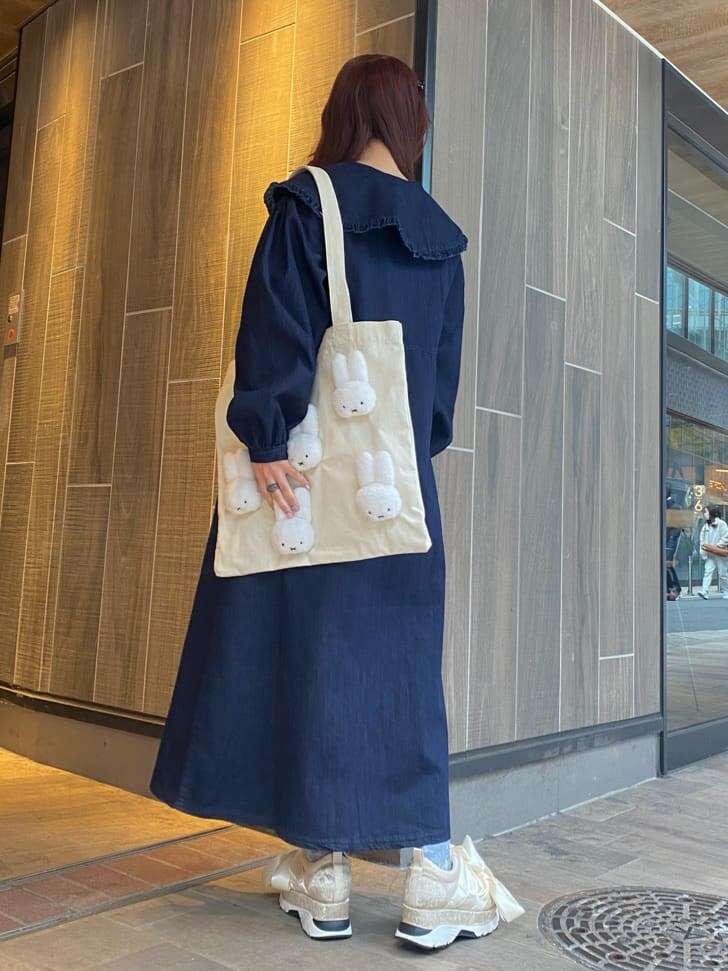 ブルー系のワンピース、ホワイト系のスニーカー、ホワイト系のトートバッグを着用したレディースの冬コーディネートの3枚目の写真