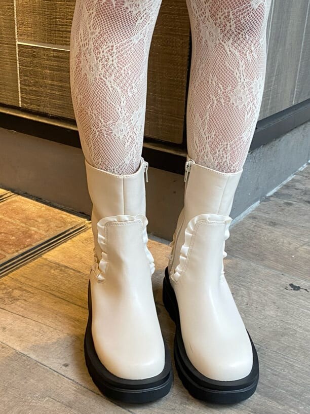 ホワイト系のニット/セーター、ホワイト系のブーツ、ブルー系のチュニックを着用したレディースの秋コーディネートの6枚目の写真