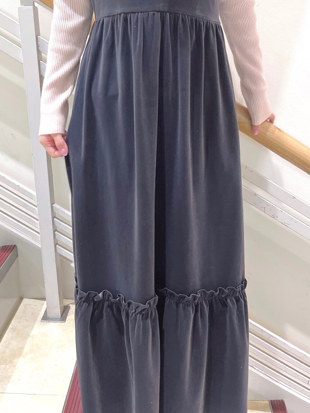 ピンク系のニット/セーター、グレー系のワンピース、ホワイト系のパンプスを着用したレディースの冬コーディネートの9枚目の写真