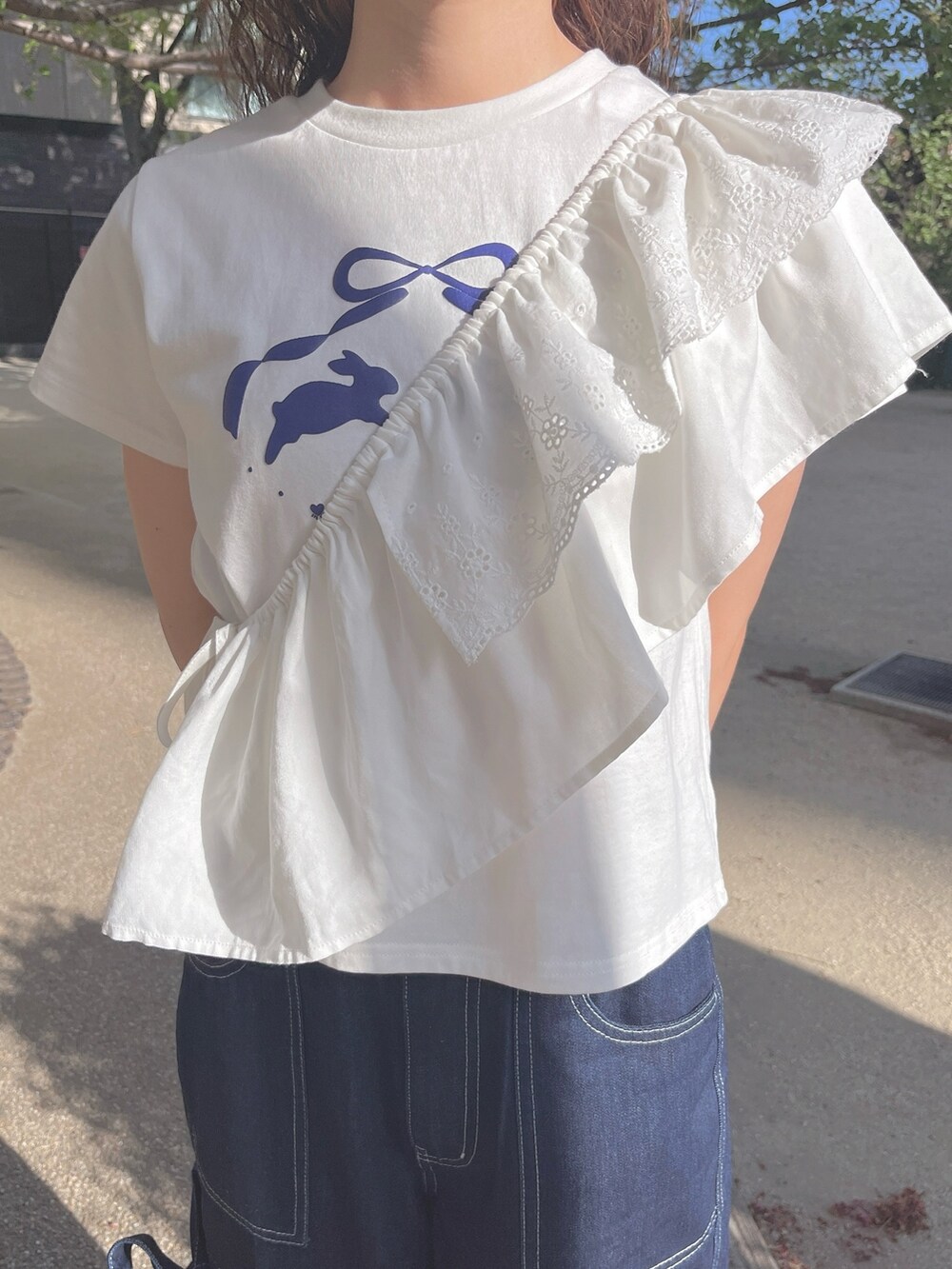 ホワイト系のTシャツ/カットソー、ブルー系のデニムパンツ、ホワイト系のスニーカーを着用したレディースの春コーディネートの4枚目の写真