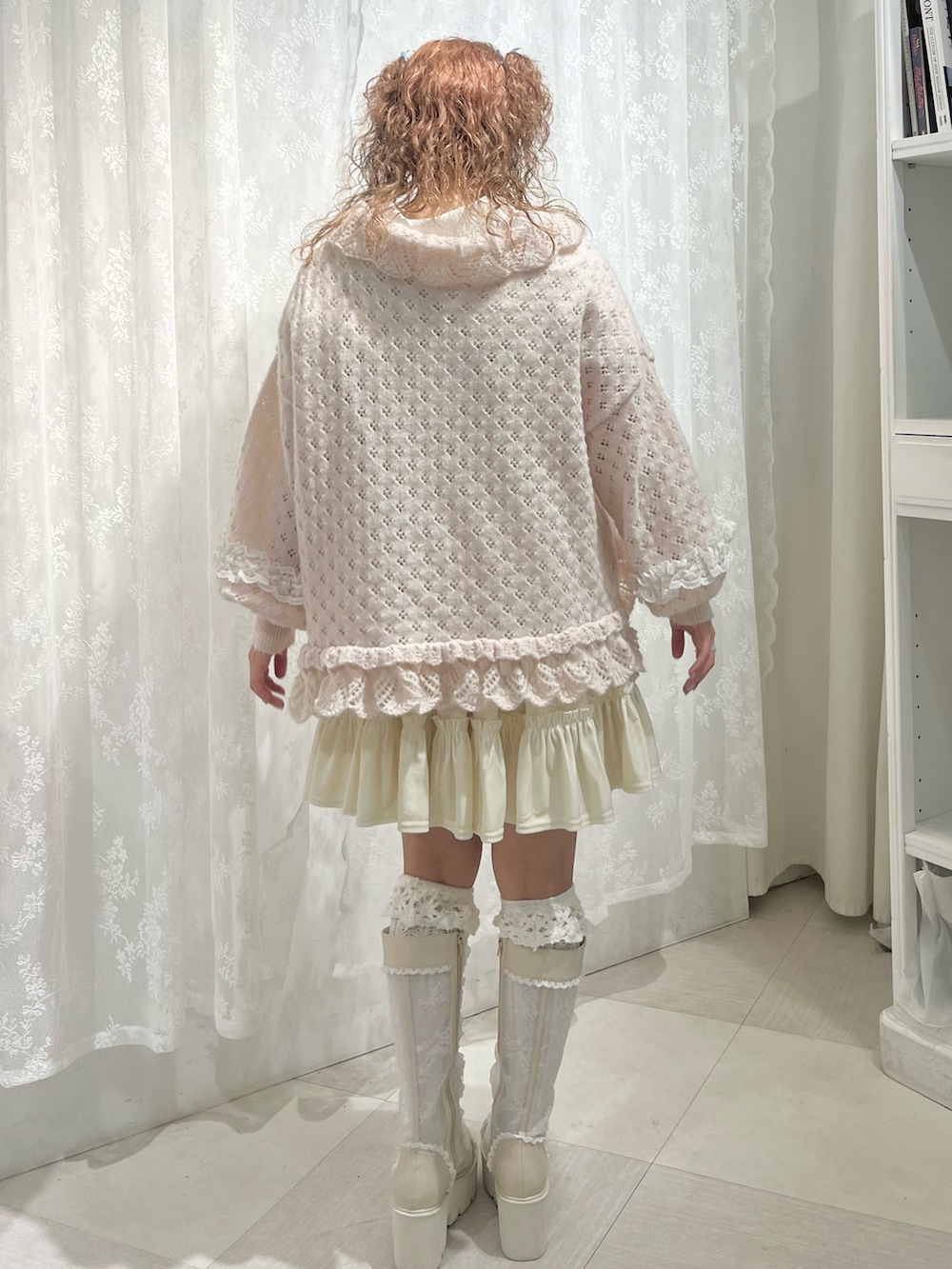ピンク系のニット/セーター、ホワイト系のワンピース、ホワイト系のシャツ/ブラウスを着用したレディースの春コーディネートの4枚目の写真