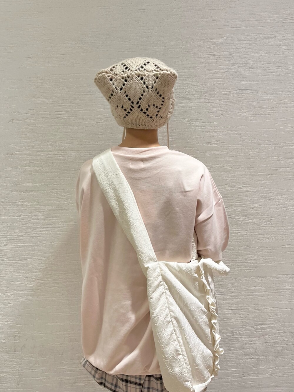 ピンク系のスウェット、ベージュ系のスカート、ホワイト系のトートバッグを着用したレディースの秋コーディネートの7枚目の写真