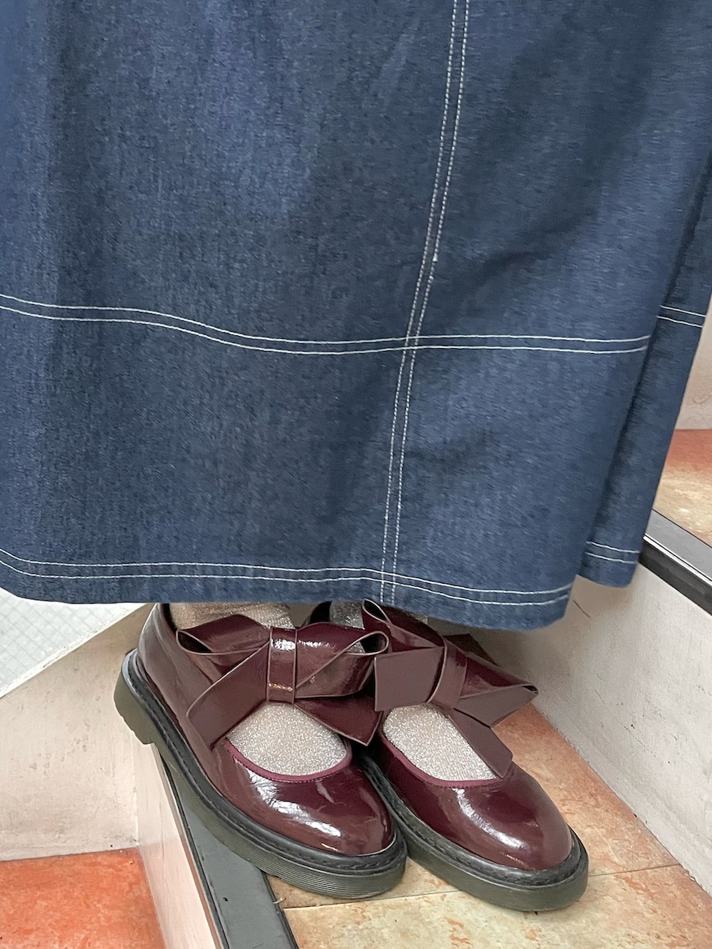 ブルー系のワンピース、ホワイト系のカーディガン/ボレロ、レッド系のその他シューズを着用したレディースの冬コーディネートの6枚目の写真