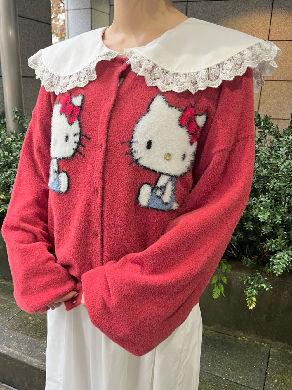 レッド系のカーディガン/ボレロ、ホワイト系のワンピース、レッド系のバレエシューズを着用したレディースの秋コーディネートの7枚目の写真