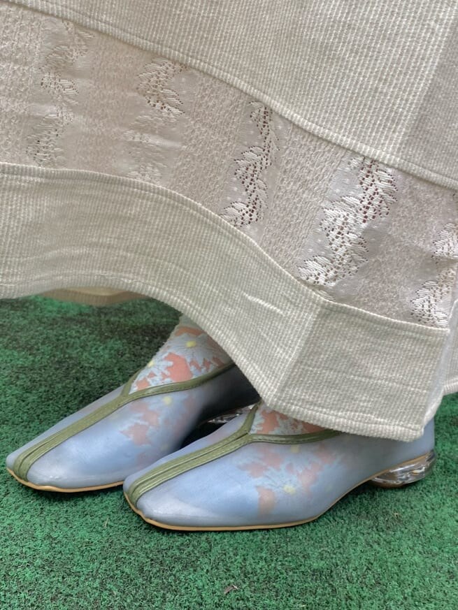 ホワイト系のワンピース、ブルー系のパンプス、ブルー系のトートバッグを着用したレディースの春コーディネートの6枚目の写真