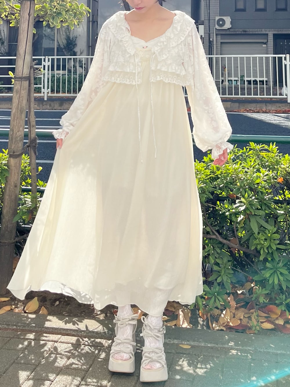 ホワイト系のカーディガン/ボレロ、ホワイト系のワンピース、ベージュ系のサンダルを着用したレディースの冬コーディネートの4枚目の写真